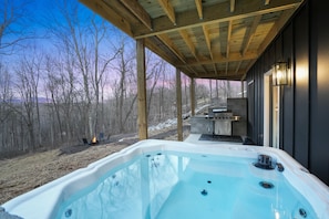 A hot tub under a wooden pergola with a view of a forested area. - Timberline Retreat | Hocking Hills, Hot Tub (Creola)