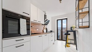 Eine moderne Küche mit weißen Schränken, einem schwarzen Backofen und einer Holz Arbeitsplatte.