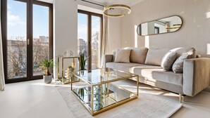 Ein modernes Wohnzimmer mit einem Glastisch, einer Couch und einem großen Spiegel an der Wand.