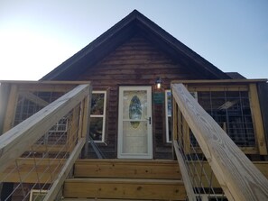 Una cabaña de madera con puerta blanca y un letrero que dice "KOBEL'S ROOST".