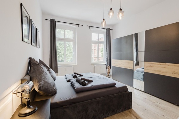 Sunlit bedroom with large wardrobe and refined lighting design.