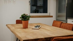 A dining table with a potted plant and a board game. - Passau Appartements|Central|Stylish|Comfortable (Passau)