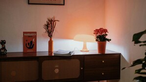 A wooden desk with a lamp, a book titled 'Marrakech Jardin', and two potted plants. - Passau Appartements|Central|Stylish|Comfortable (Passau)