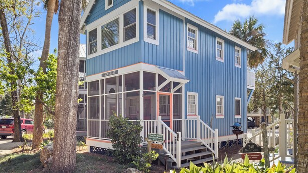 A blue house with a porch, a sign indicating it's a vacation rental, and a number 240 sign. - Clove Coastal Cottage - Steinhatchee Landing (Steinhatchee)