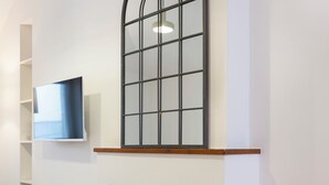 A modern interior with a fireplace, a mounted TV, and a decorative wall piece. - Studio Secundo (Metz)