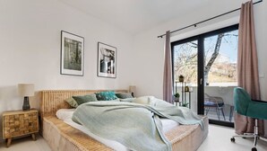 Een moderne slaapkamer met een groot bed, een bureau en uitzicht op de omgeving.