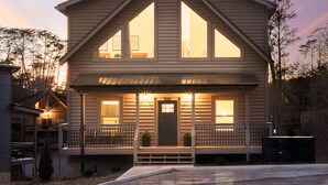 A two-story house with a front porch, large windows, and a visible address number.