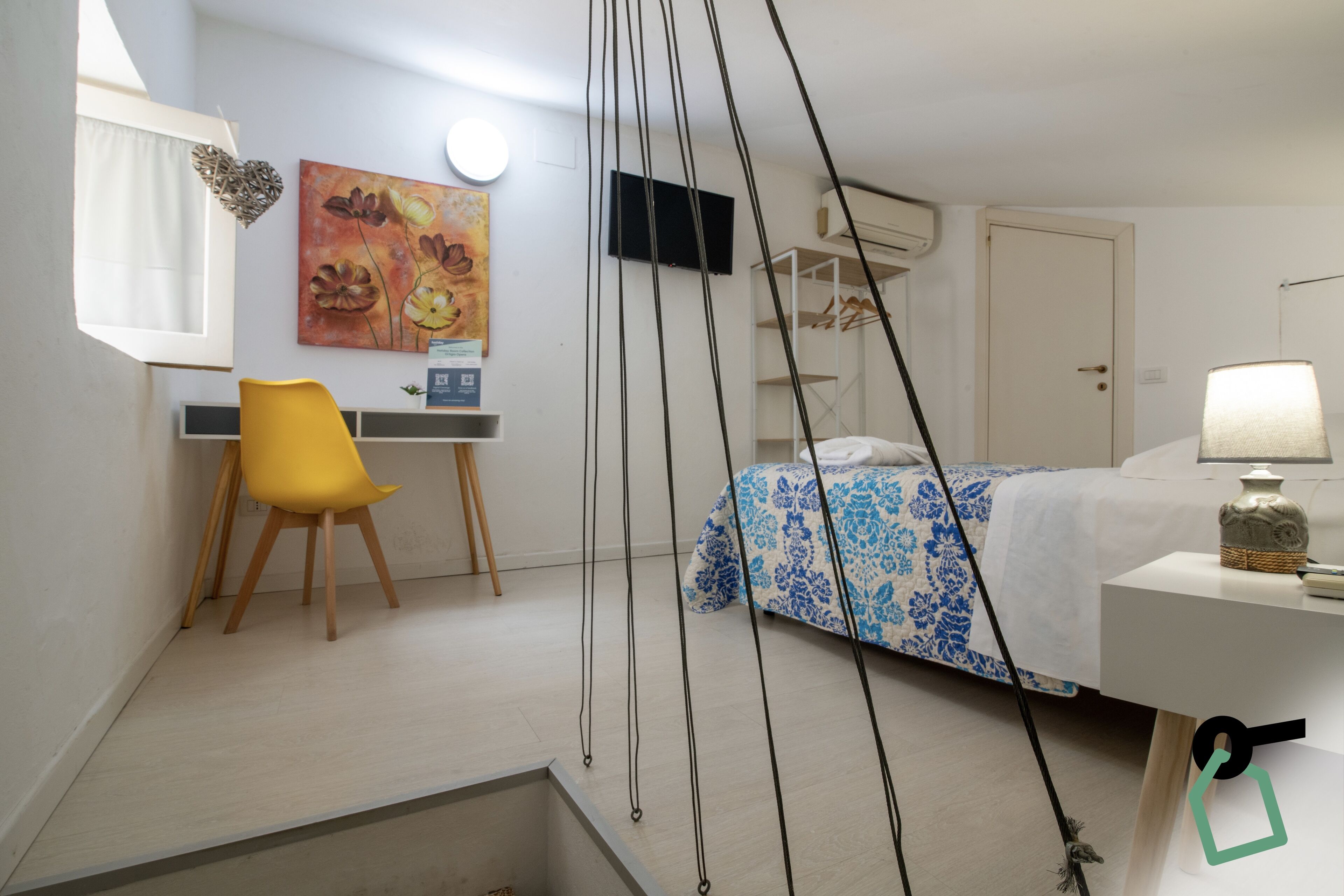 Une chambre à coucher avec un lit, un bureau, une chaise et un téléviseur.