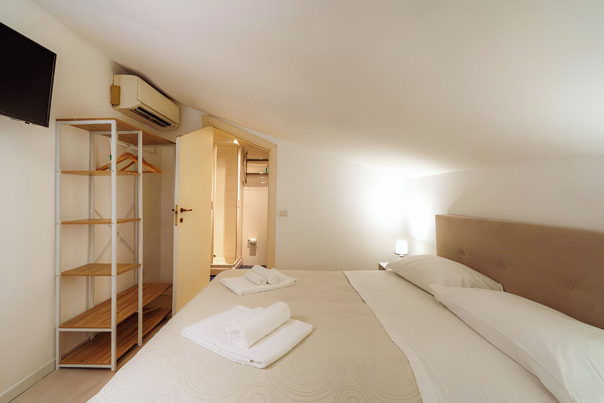 Une chambre d’hôtel équipée d’un lit, d’une armoire et d’un appareil de climatisation.