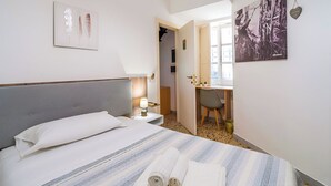 Una camera d'albergo con un letto, una scrivania e una sedia.