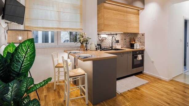 A modern kitchen with a central island, wooden cabinets, and a built-in oven. - Northern Blues (Rijeka)