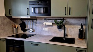 A kitchen with a built-in oven, a sink, and a countertop. - JUPAS° | Premium Apartments - Kylltalperle (Kordel)