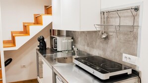 Una cocina compacta con estufa integrada, cafetera y tostadora.