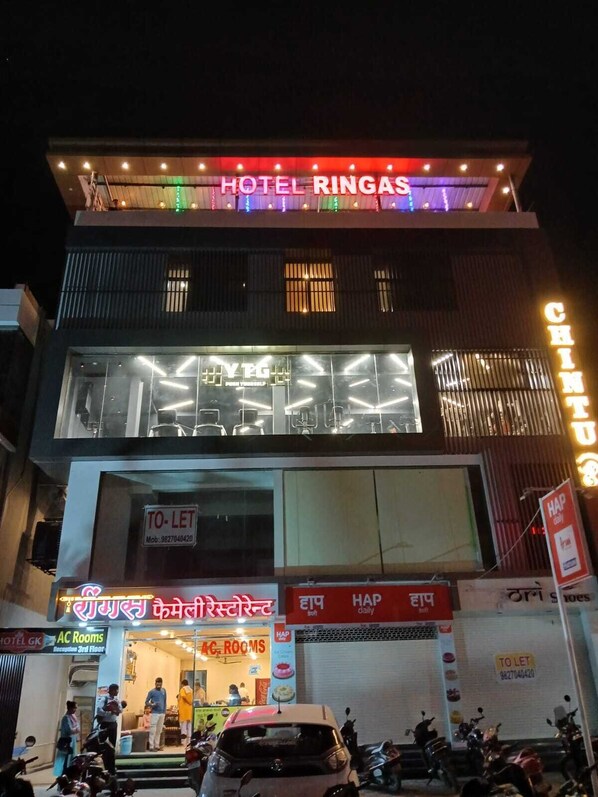 A hotel named 'Hotel Ringas' with a 'To-Let' sign, AC rooms, and a visible entrance with people and parked vehicles. - Wishotel Premier Hotel Ringas  (Dewas)