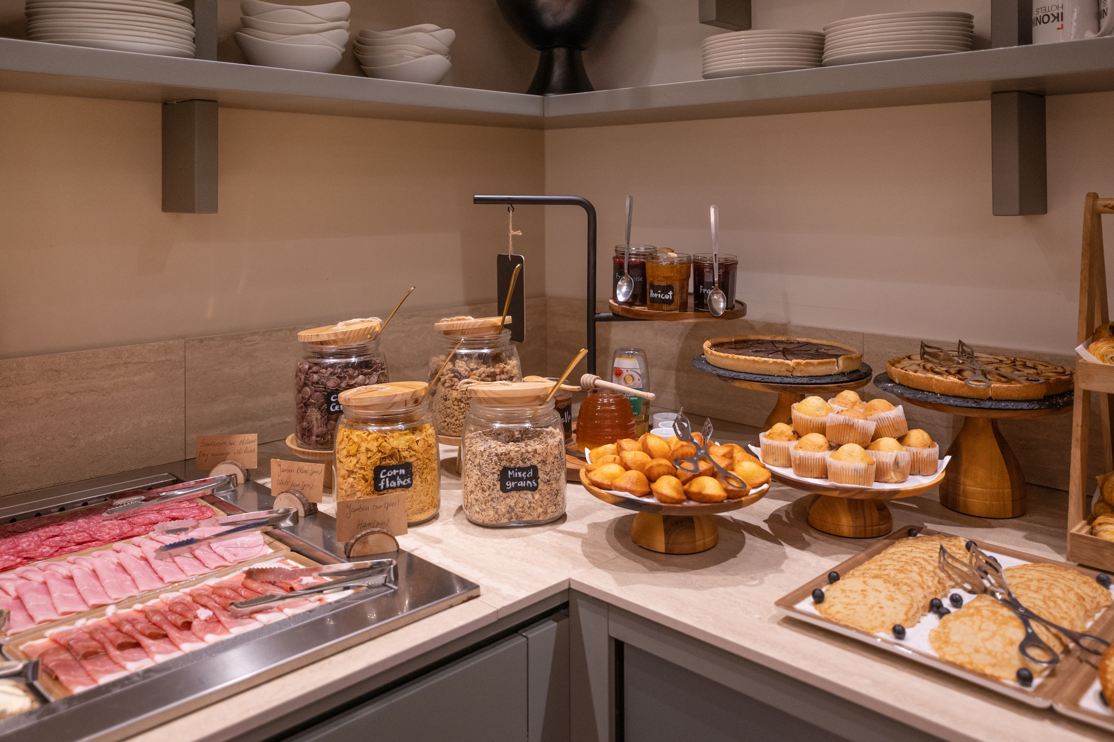 Buffet com diversos alimentos, incluindo carnes, cereais e doces.
