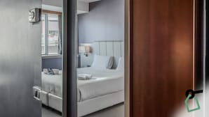Une chambre d’hôtel avec un lit, une table de chevet, une lampe et une fenêtre.