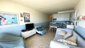 A compact living space with a kitchenette, a dining area, and a TV. - Cozy One-bedroom Apartment With sea View (Middelkerke)