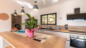 A modern kitchen with a wooden island, pendant lights, a large window, and a built-in oven. - 150m2 4 bedroom family home located in San gavino 10min from figari (Figari)