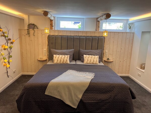 A bedroom with a large bed, two bedside tables, a headboard, and two windows. - Vacation home "AhrIdylle" - Hiking, wellness & family time with dog in the Ahr valley (Bad Neuenahr-Ahrweiler)