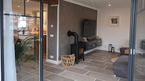 Een moderne woonkamer met een open haard, een televisie en een bank.
