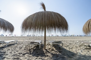 A beach with lounge chairs and umbrellas. - TURQUESA Apartment (La Pineda)