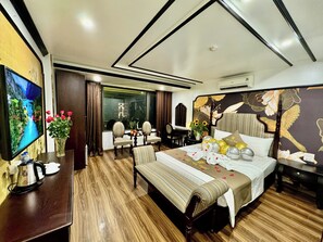 A hotel room with a large bed, a TV, a desk, and a chair. - Bao Anh Hotel (Hanoi)