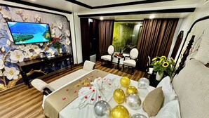 A hotel room with a large bed, a TV on the wall, a desk, and a view of the outdoors. - Bao Anh Hotel (Hanoi)