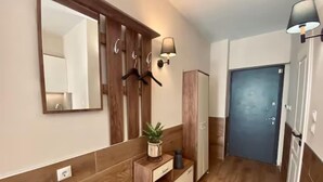 Une salle de bain moderne avec un meuble-lavabo en bois, un miroir et un luminaire fixé au mur.