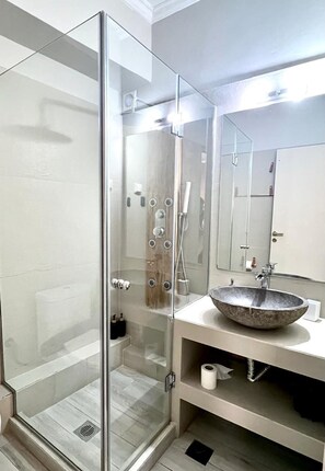 A modern bathroom with a glass-enclosed shower, a large mirror, and a vessel sink. - Monastiraki 312 Superhost Hub (Athens)
