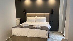 A modern bedroom with a large bed, two bedside lamps, and a nightstand. - Monastiraki 112 - 38m2 Superhost Hub (Athens)