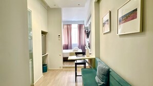 Una sala de estar moderna con un sofá verde, una mesita y un televisor montado en la pared.