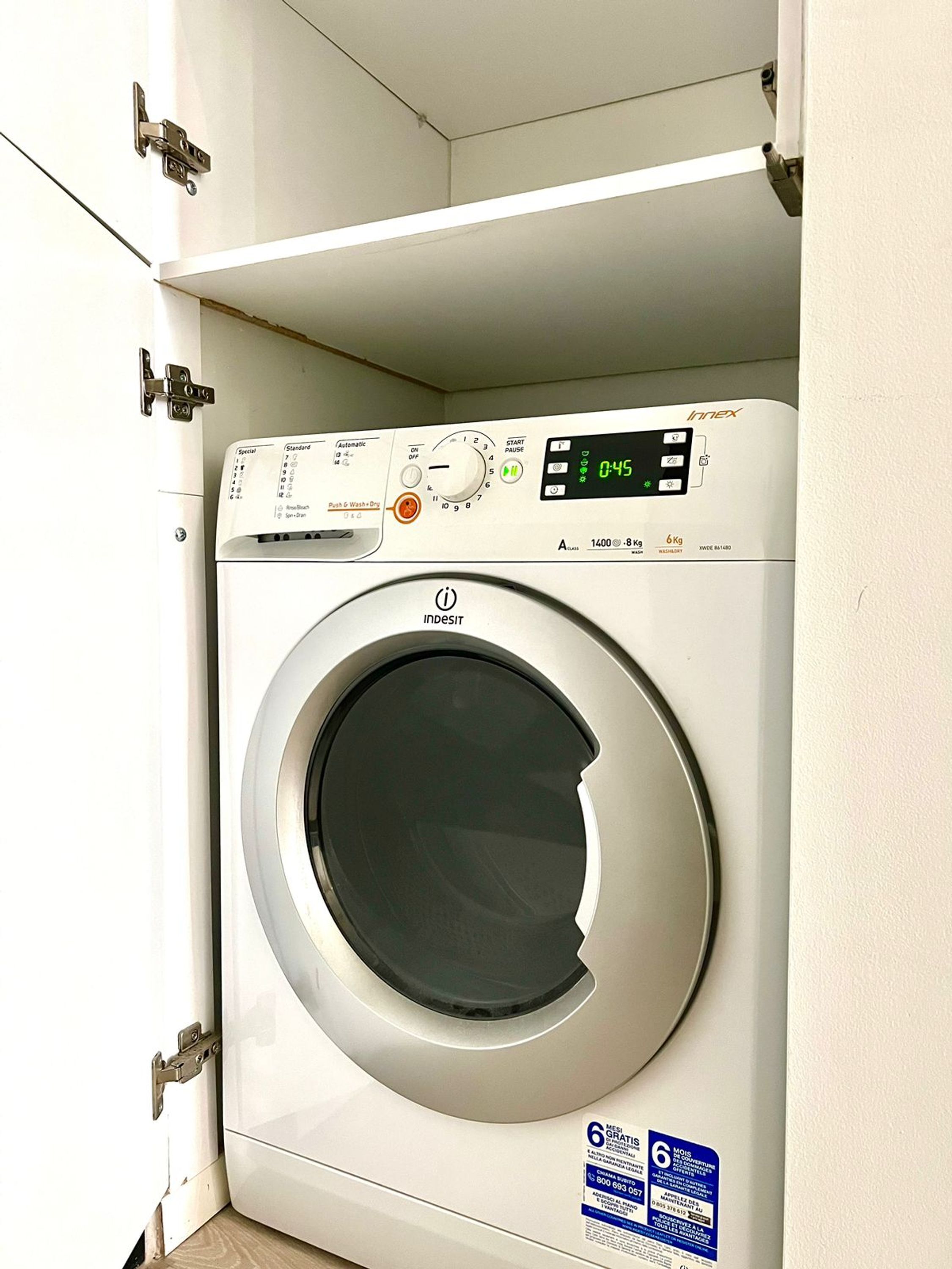 Una lavadora de carga frontal con pantalla digital, panel de control e indicación de capacidad de 6 kg.
