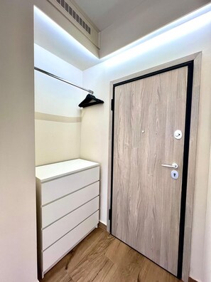 A room with a white wardrobe, a wooden door, and a hanging coat rack. - Monastiraki 308 Superhost Hub (Athens)