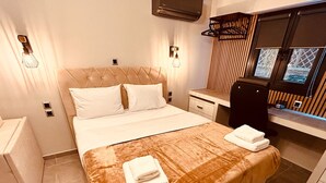 Een moderne hotelkamer met een groot bed, nachtkastjes, een bureau en een raam met zonwering.