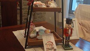 A wooden table with a tray holding various items, a nutcracker, and a framed picture with a bear illustration. - Vitina Number 5 House (Gortynia)