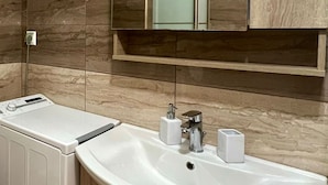 A modern bathroom with a built-in sink, a mirror, and a towel rack. - Monastiraki 103 Superhost Hub (Athens)