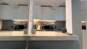 A modern kitchen with white cabinets, a countertop, and built-in appliances including a microwave and toaster.
