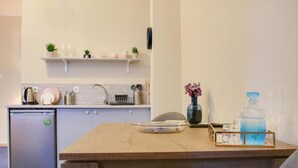 Una cucina compatta con frigorifero, lavello e piano di lavoro con diversi utensili da cucina.