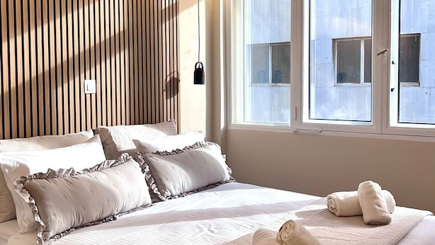 A bedroom with a large bed, a wooden slat headboard, and a window with blinds. - Monastiraki 304 Superhost Hub (Athens)