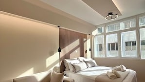 A modern bedroom with a bed, a sofa, and a window with blinds. - Monastiraki 304 Superhost Hub (Athens)
