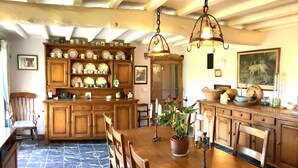 Una cocina tradicional con armarios de madera, piso de mármol e iluminación colgante.