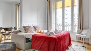 Ein Hotelzimmer mit Bett, Essbereich und Blick auf die Stadt.