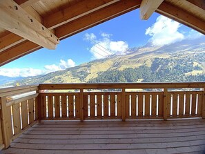 A wooden deck with a view of a mountainous landscape.