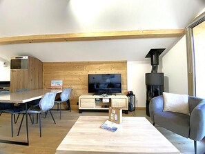 A modern living room with a wooden ceiling, a flat-screen TV, a sofa, a coffee table, and a fireplace. - 200m from ski slopes, 2nd floor, tv, 43m², Méribel (Méribel - Les Allues)