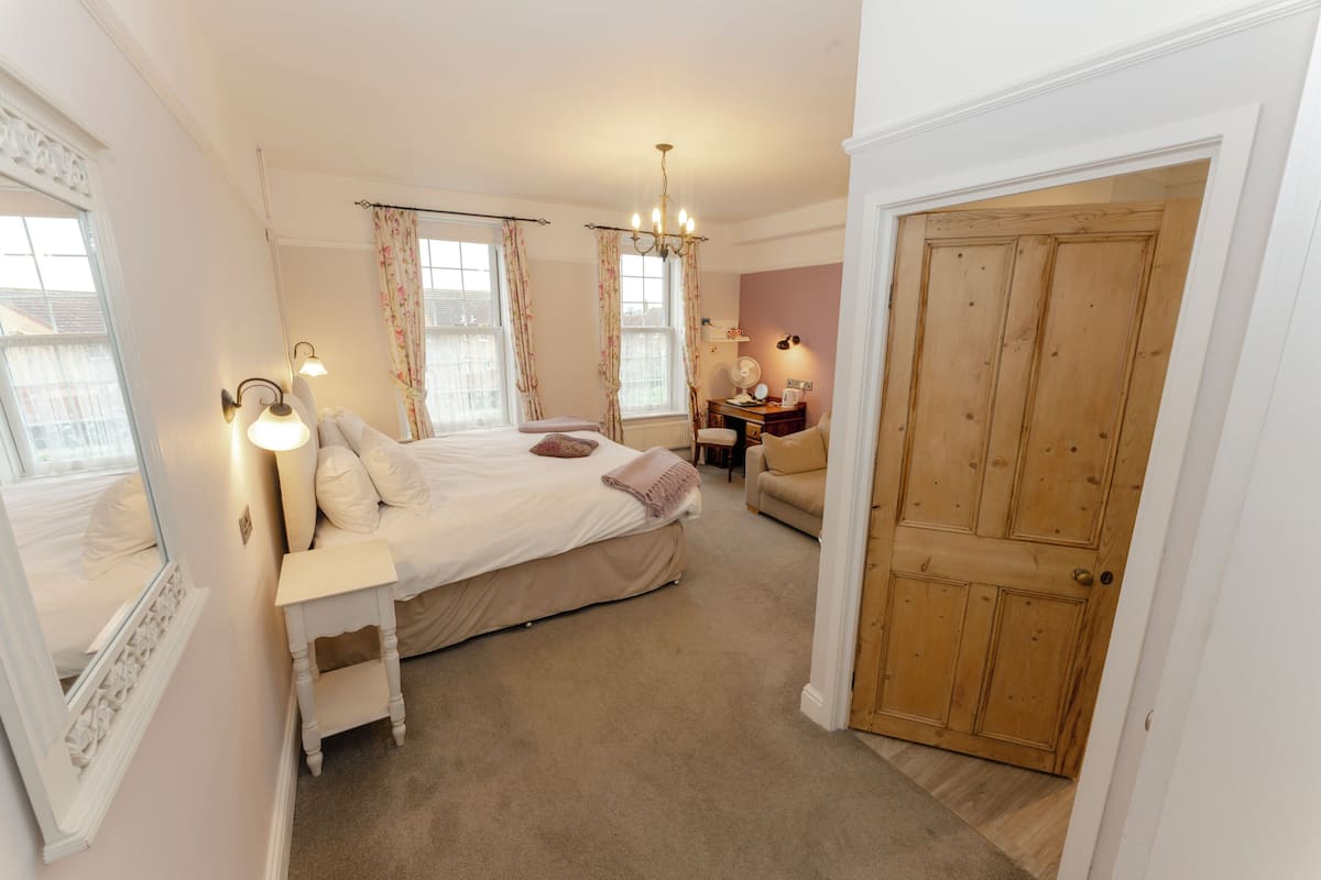 A bedroom with a bed, bedside table, and a desk with a chair.