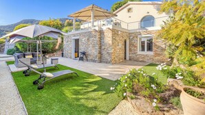 A stone house with a patio, outdoor furniture, and a view of the mountains.