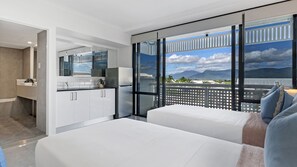Une chambre d’hôtel moderne avec un balcon, une grande fenêtre et une vue sur les montagnes.
