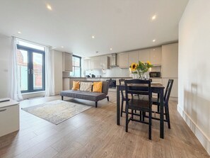 A modern apartment with a dining area, sofa, and kitchen. - *New* | St James - City Centre Modern Apartment (Canterbury)