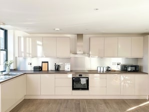 A modern kitchen with white cabinets, a built-in oven, and a microwave. - South-Facing Balcony Apt, Canterbury City Centre (Canterbury)