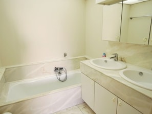 A bathroom with a bathtub, two sinks, and a mirror above the sinks. - Apartment in Middelkerke With Sea Views (Middelkerke)